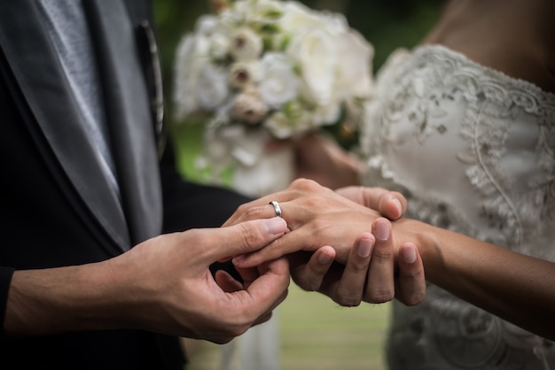 Feche acima do noivo veste a noiva do anel no dia do casamento. amor, feliz casar com o conceito. Foto gratuita