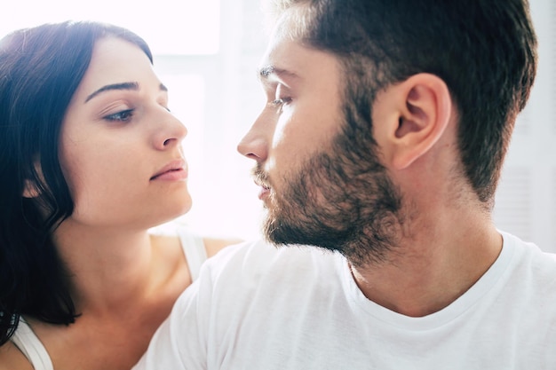 Feche O Retrato Do Jovem Lindo Casal Apaixonado Enquanto Eles Estão Sentados Na Cama E Beijando 0270