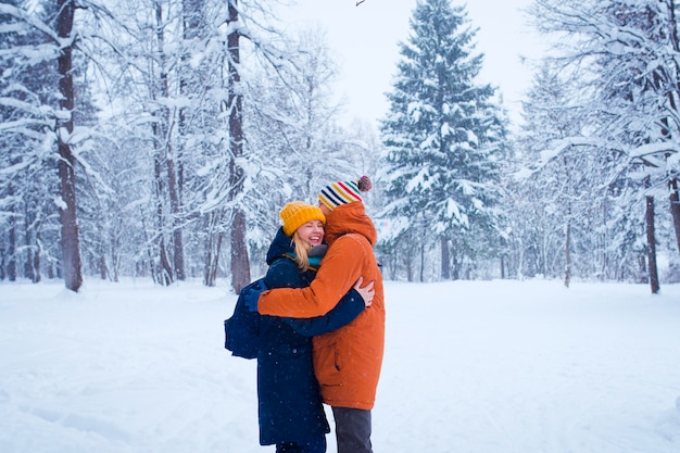 Feliz casal apaixonado na floresta de inverno nevado Foto Premium