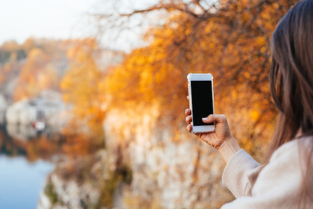 Feminino mão segurando um telefone, tela preta Foto gratuita