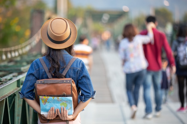 Femininos turistas na mão têm um mapa de viagem feliz. Foto gratuita