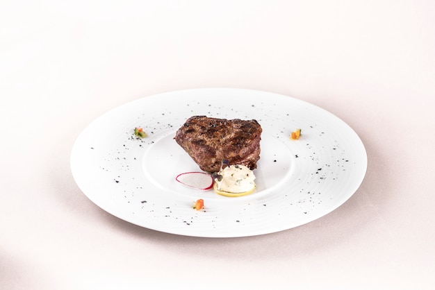 Filé mignon suculento, servido com manteiga e ervas, decorado com rabanete Foto Premium