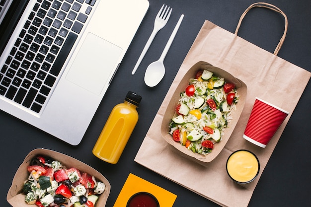 Flat lay arranjo com salada e laptop Foto gratuita