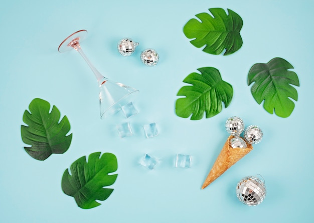 Flat lay com bolas de discoteca no cone, cubos de gelo, copo de coquetel Foto Premium