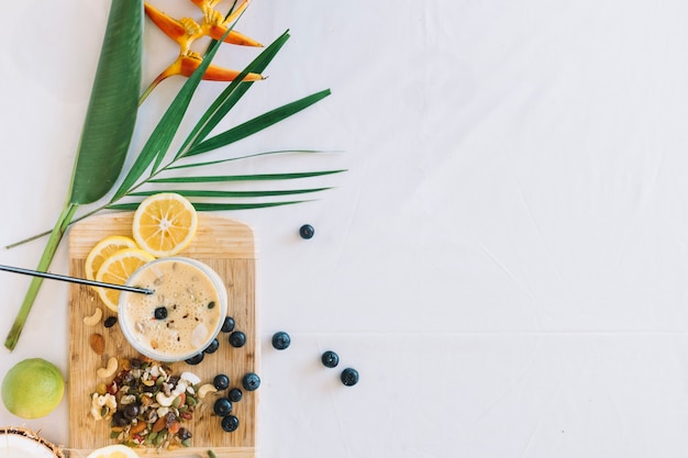 Flor ave do paraíso com smoothies saudáveis com dryfruits em fundo branco Foto gratuita