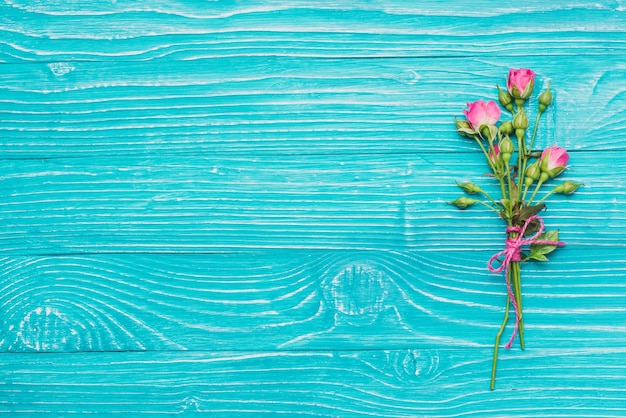 Flores decorativas no azul superfície de madeira  Baixar 