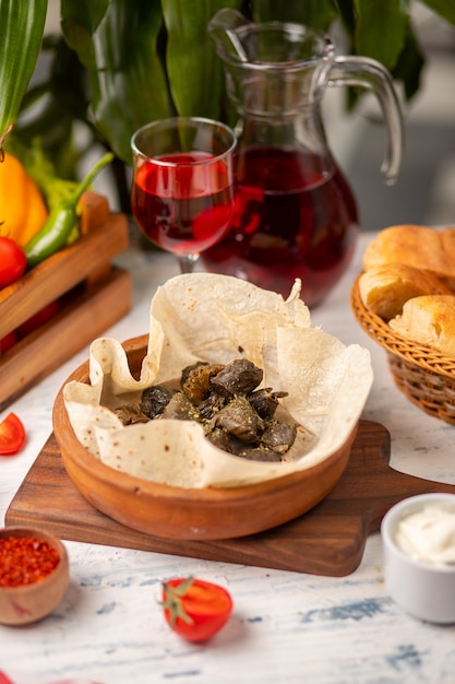 Folhas de uva verdes recheadas com carne, arroz, ervas, cebola e cozidos em azeite, servido com panificação e bread.yarpag dolmasi, yaprak sarmasi Foto gratuita