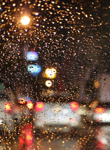 Fora de foco de engarrafamento na noite chuvosa vista do pára-brisa do carro com pingos de chuva Foto Premium