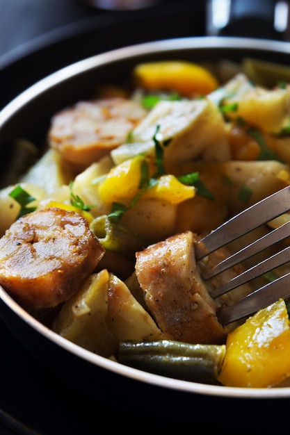 Foto macro vertical de batatas fritas com salsichas, feijão e pimenta Foto Premium