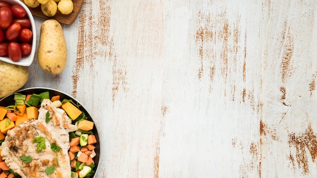 Frango na chapa e legumes na mesa pintada de grunge Foto gratuita