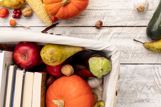 Frutas e legumes na cesta com livros Foto gratuita
