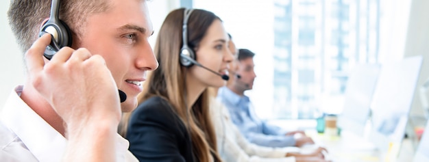 Funcionário do operador masculino com equipe trabalhando call center Foto Premium