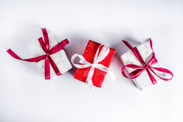Fundo de natal para cartão, com galho de árvore do abeto e caixas de presentes com fitas, na vista superior de fundo branco, cópia espaço para texto Foto Premium