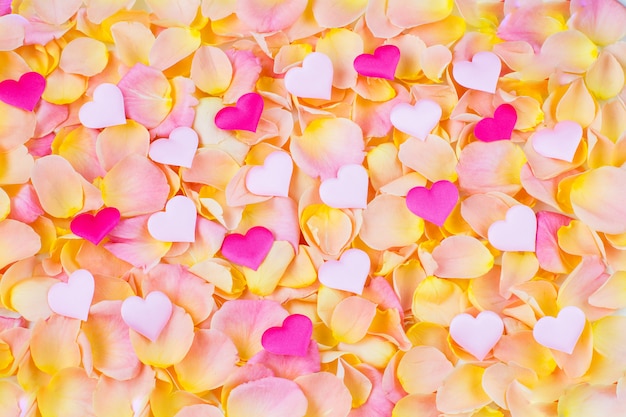 Fundo de rosa pétalas de rosa corações multicoloridos de cetim Foto Premium