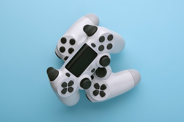 Gamepad de joystick dois branco, consola de jogos na moda moderno colorido azul fundo pin-up Foto Premium