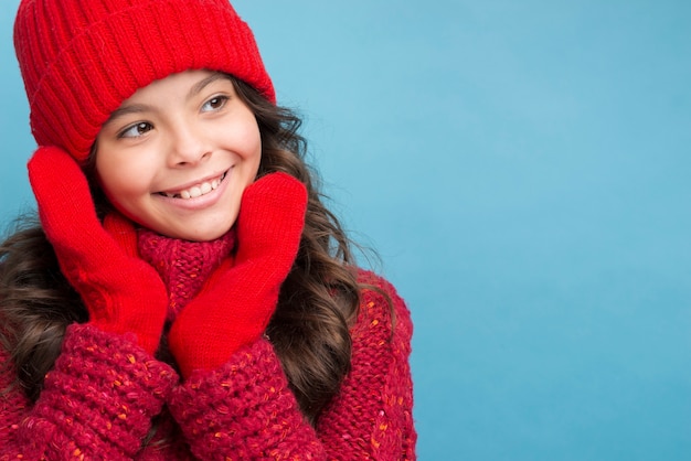 Garota com roupas de inverno vermelho, olhando para a esquerda Foto gratuita