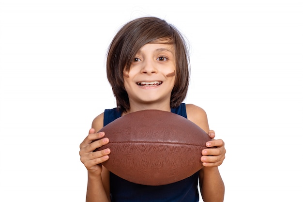 Garotinho com bola de futebol americano. Foto Premium