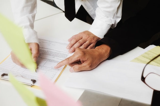 Gerente asiático de empresas empresariais que analisa o dado em gráficos e digitando no computador, fazendo anotações em documentos na mesa no escritório, cor vintage, foco seletivo. conceito de negócios. Foto gratuita