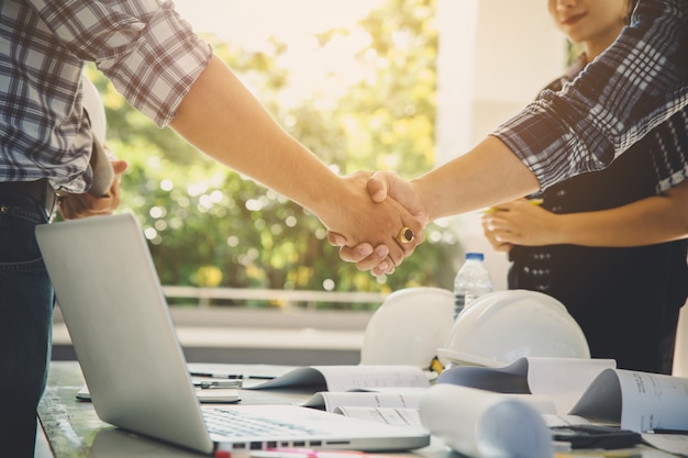 Gerente de construção e engenheiro equipe apertando a mão durante a reunião Foto Premium