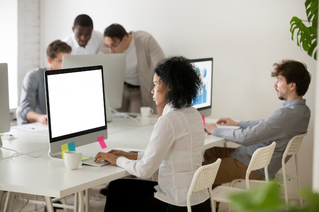 Gerente de mulher afro-americana focada em trabalho de computador no escritório multi-étnica Foto gratuita