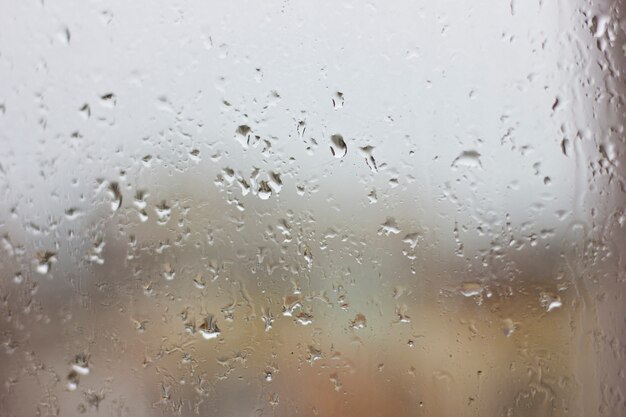 Gotas de chuva em uma janela molhada. umidade cinza Foto Premium