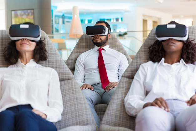 Grupo de colegas em fones de ouvido vr assistindo apresentação virtual Foto gratuita