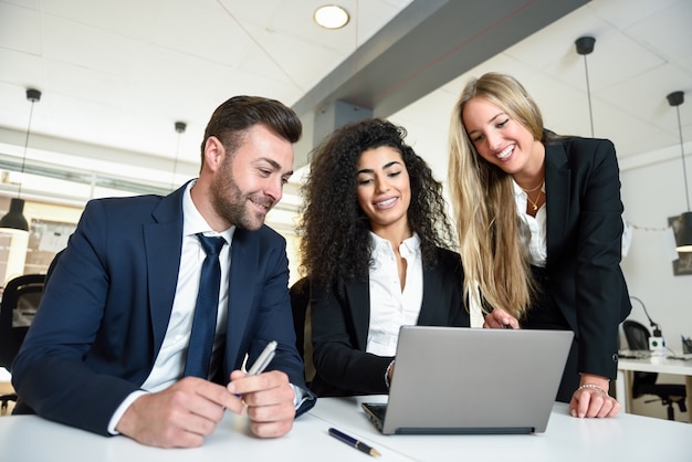 Grupo multiétnico de três empresários reunidos em um 