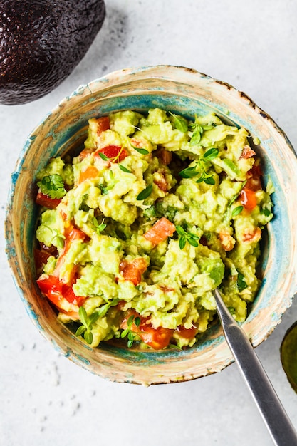 Guacamole fresco do tomate do abacate em uma bacia conceito saudável do alimento baseado da planta Foto Premium
