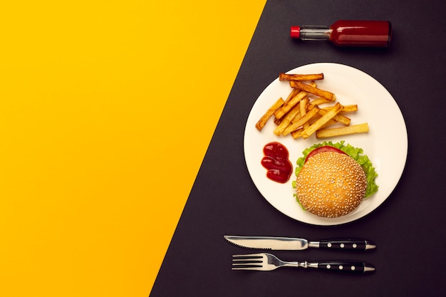 Hambúrguer de vista superior com batatas fritas com espaço de cópia Foto gratuita