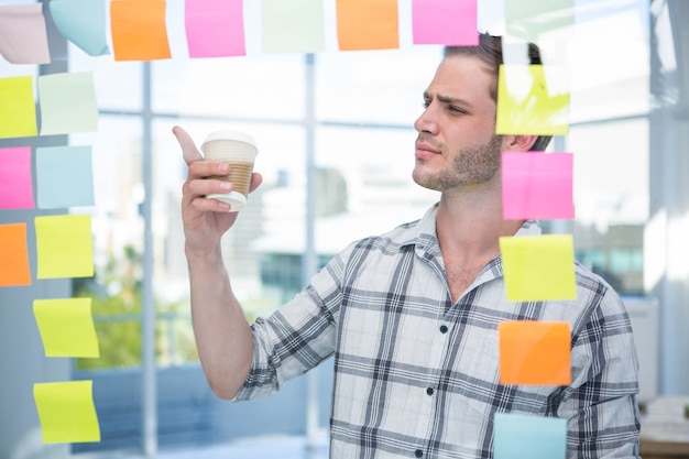 Hipster Homem Apontando Para Post It No Escritorio Foto Premium