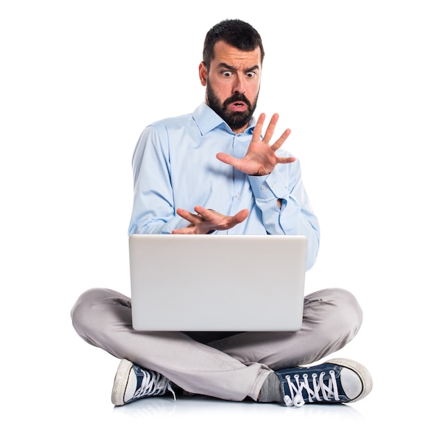 Homem amedrontado com laptop Foto gratuita
