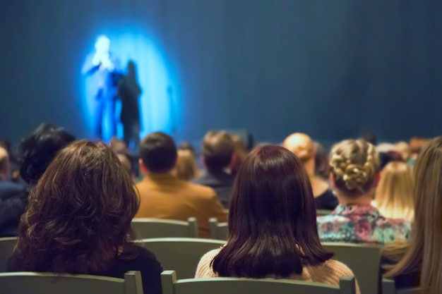 Homem aparece no palco no teatro com muitas pessoas Foto Premium