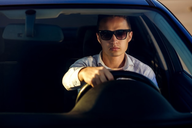 Homem Bonito Sério Atraente Na Camisa Branca E óculos De Sol Dirigindo Um Carro Caro Foto Premium 