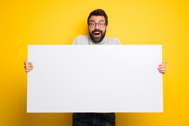 Homem com barba e gola alta segurando um cartaz para inserir um conceito Foto Premium