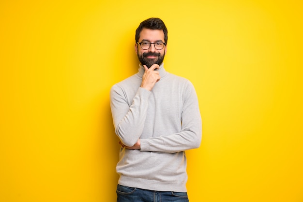Homem com barba e gola alta sorrindo e olhando para a frente com cara confiante Foto Premium