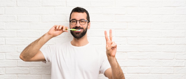Homem com barba, escovar os dentes Foto Premium