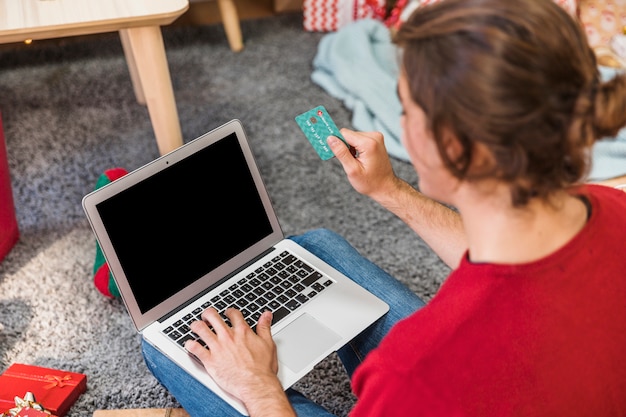 Homem, com, cartão crédito, usando computador portátil Foto gratuita