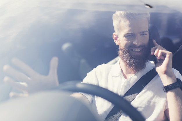 Homem com uma barba senta-se ao volante de um veículo elétrico Foto Premium