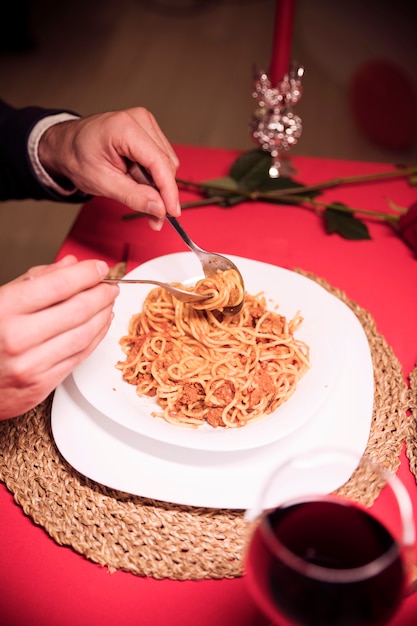 Homem comendo macarrão na mesa festiva | Foto Grátis