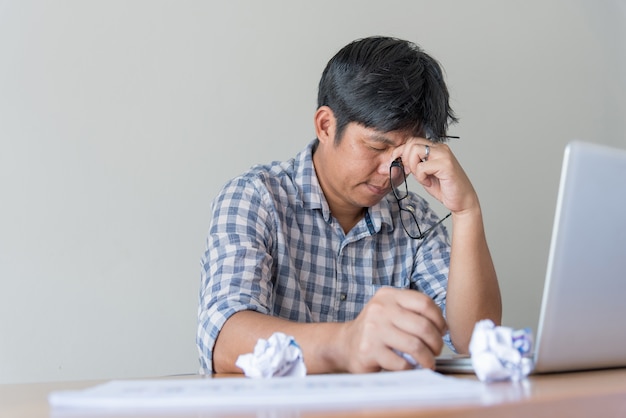 Homem de negócios cansado na mesa com laptop procurando uma saída da situação difícil. pensativo homem frustrado estressado trabalhando por muito tempo no computador, escolhe solução, pensando em problema difícil Foto Premium