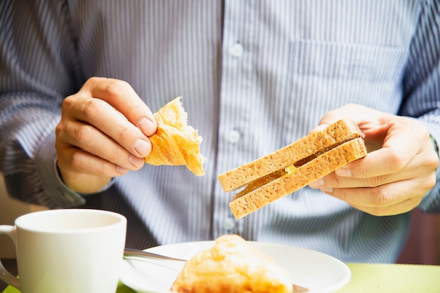 Homem de negócios comer o café da manhã americano situado num hotel Foto gratuita