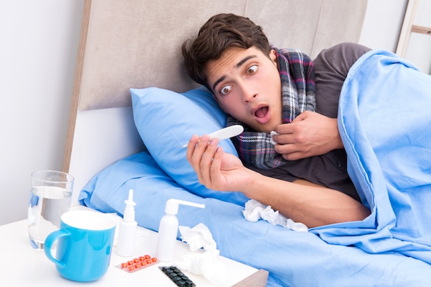 Homem doente com gripe, deitada na cama Foto Premium