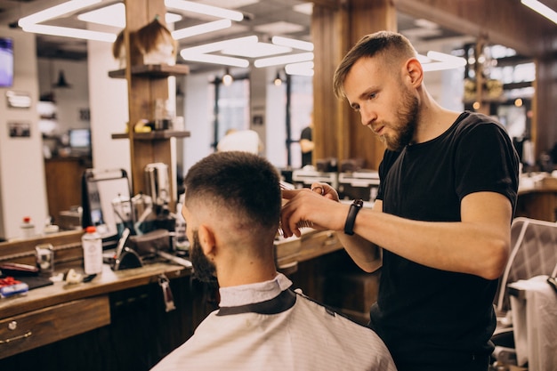 Homem em um salão de barbearia fazendo o corte de cabelo e barba Foto Grátis
