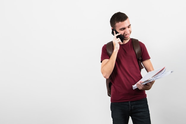 Homem falando ao telefone e olhando suas anotações Foto gratuita