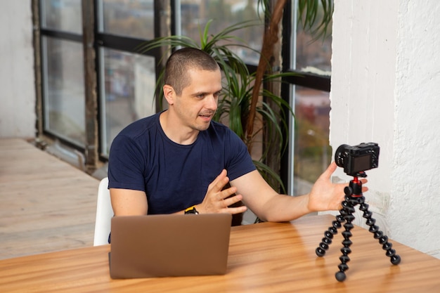 Homem gravando vídeo para seu blog ou canal de vídeo laptop e câmera