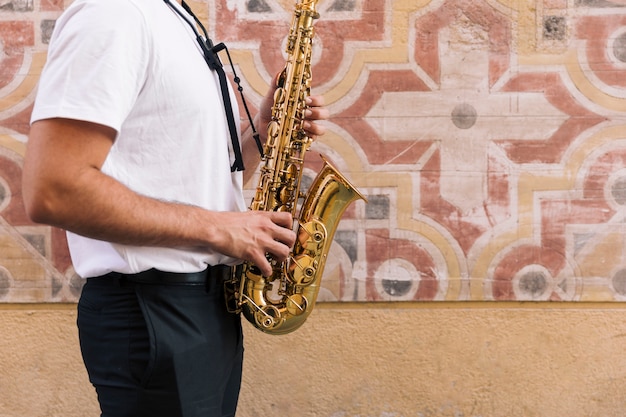 Homem, lateralmente, tocando, saxofone, com, geométrico, fundo Foto gratuita