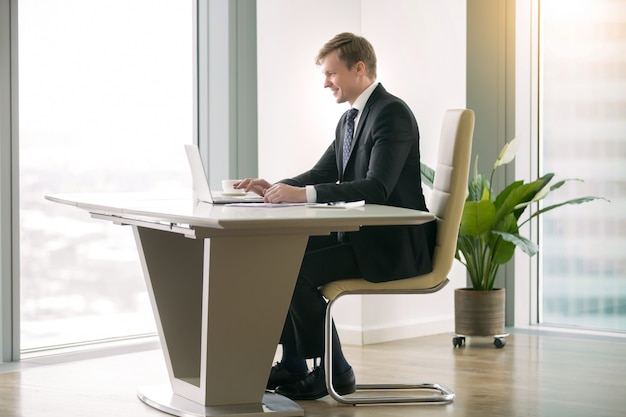 Homem negócios, trabalhando, com, laptop, em, a, moderm, escrivaninha Foto gratuita