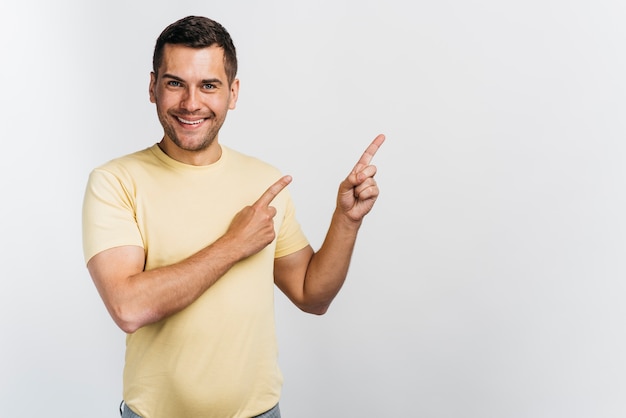 Homem Sorridente Apontando Em Um Espaço De Cópia De Direção Foto Grátis