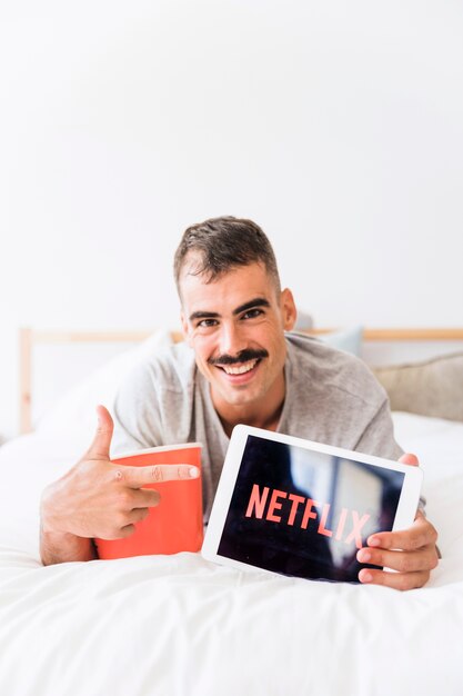 Homem sorridente com pipoca publicidade site netflix Foto gratuita