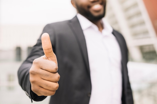 Homem sorridente gesticulando polegar para cima Foto gratuita
